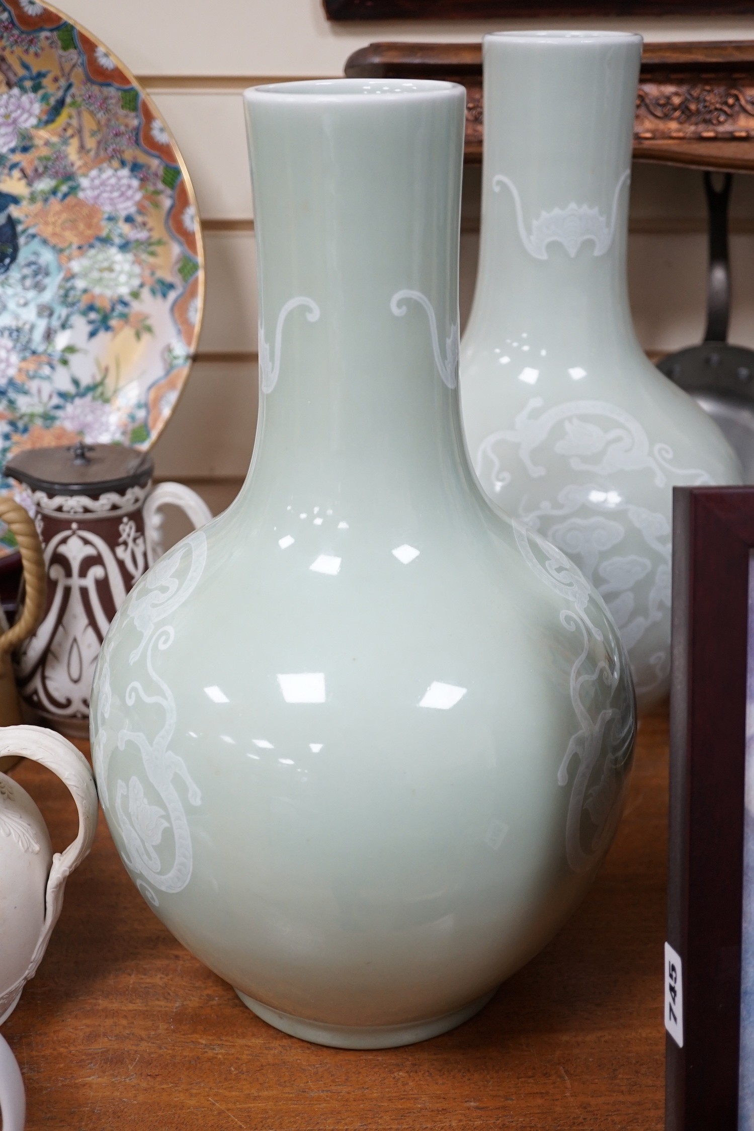 A pair of Chinese white slip decorated celadon glazed bottle vases, mid 20th century, 39cm
